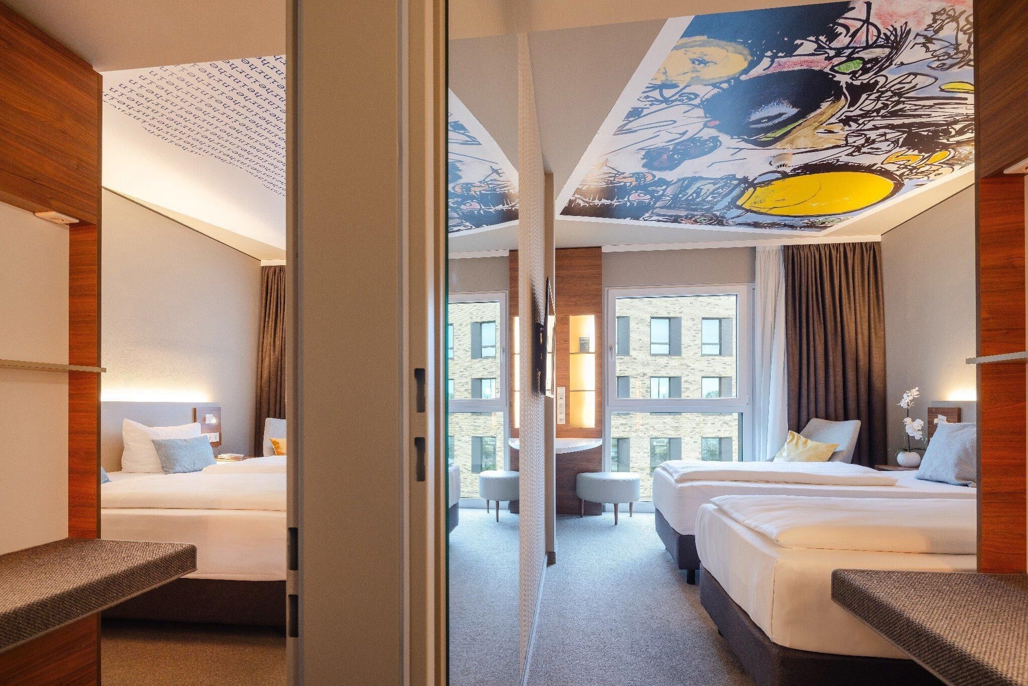 Una habitación de hotel con cama, escritorio y vistas a la ciudad.