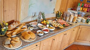 A buffet spread with various breads, pastries, fruits, and cheeses. - Styles Hotel Unterföhring (Unterfoehring)