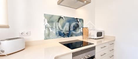 A modern kitchen with a built-in oven, a microwave, and a toaster.