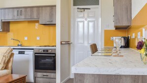 A kitchen with a built-in oven, a sink, and a countertop with a glass and a kettle. - 2 bedroom accommodation in Commondale, near Whitby (Commondale, near Whitby)