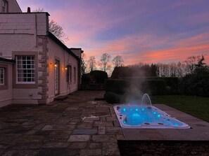 Relax in a serene outdoor setting with a hot tub overlooking the surrounding landscape.