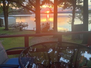 A lakeside view from a deck with a glass table reflecting the sunset. - Lake Cabin with Fantastic View--Kayak, Swim or Fish (Perryville)