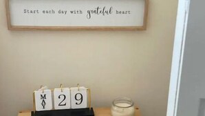 Ein Holztisch mit einem weißen Kalender, der den 29. Mai zeigt, einem dekorativen Teller und einer Kerze.