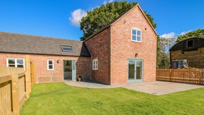 A two-story brick house with a fenced backyard and a small garden. - The Barn (Shrewsbury)