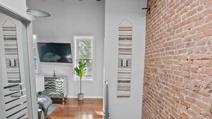 A modern interior with a wooden floor, a brick wall, and a staircase. - DC’s Southwest and Navy Yard Welcomes You! (Washington)