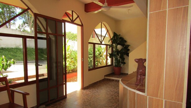 A spacious room with a large window, a ceiling fan, and a potted plant. - Hotel NICTE HA (Xpujil)