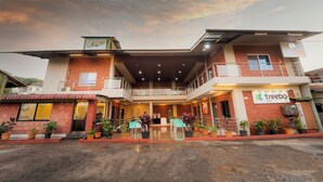 A two-story building with a balcony, potted plants, and a sign for 'treebo'. - Treebo Iceberg 700Meters From Venna Lake (Mahabaleshwar)