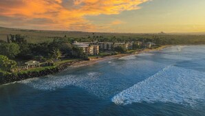 A coastal hotel with multiple buildings, a beachfront, and a view of the ocean.