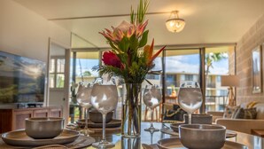 A dining table set with bowls, wine glasses, and a centerpiece of flowers.