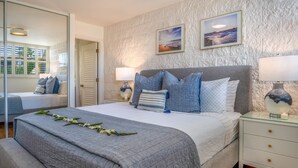 A bedroom with a bed, bedside tables, and a large mirror.