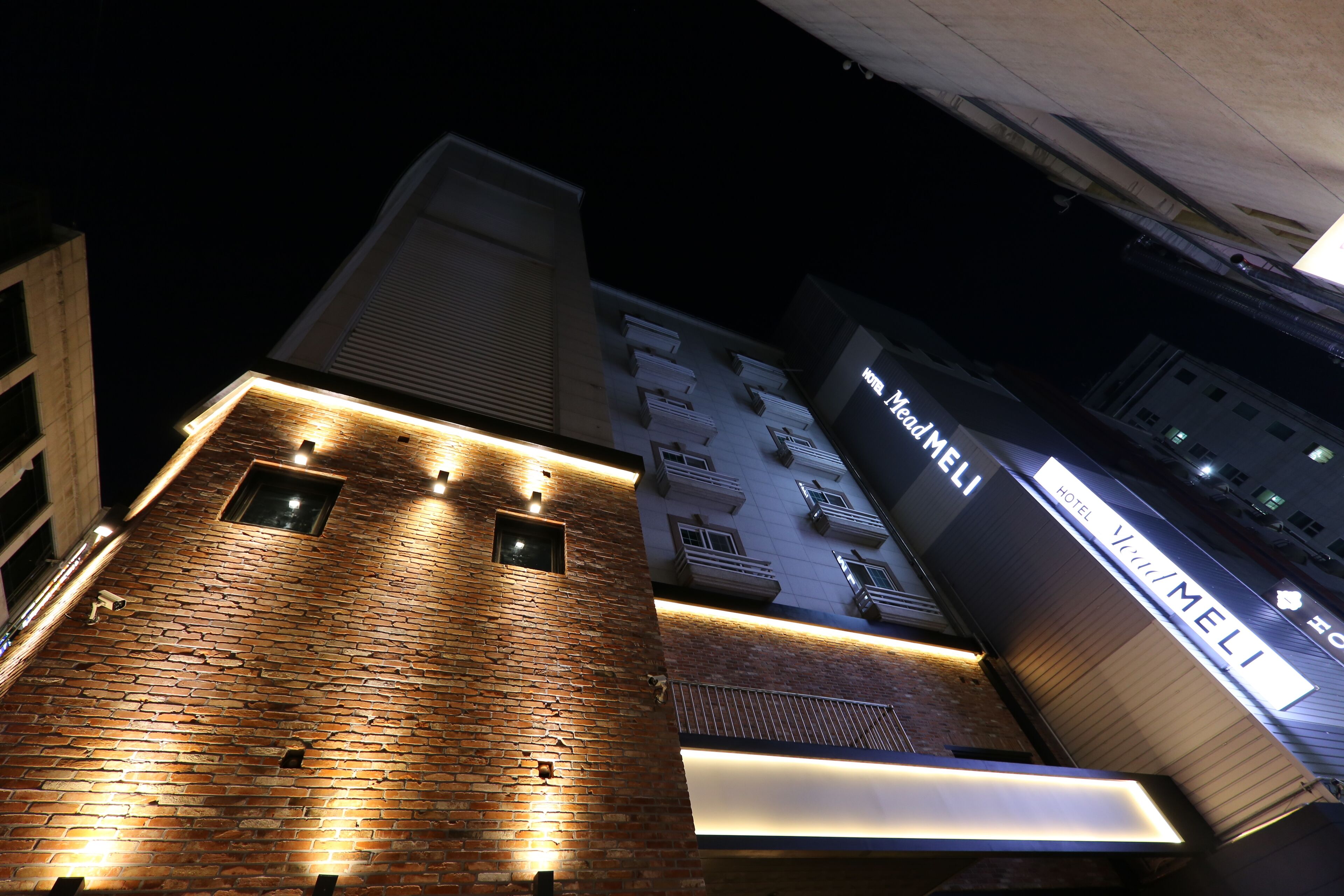 A hotel with a brick facade and illuminated signage.