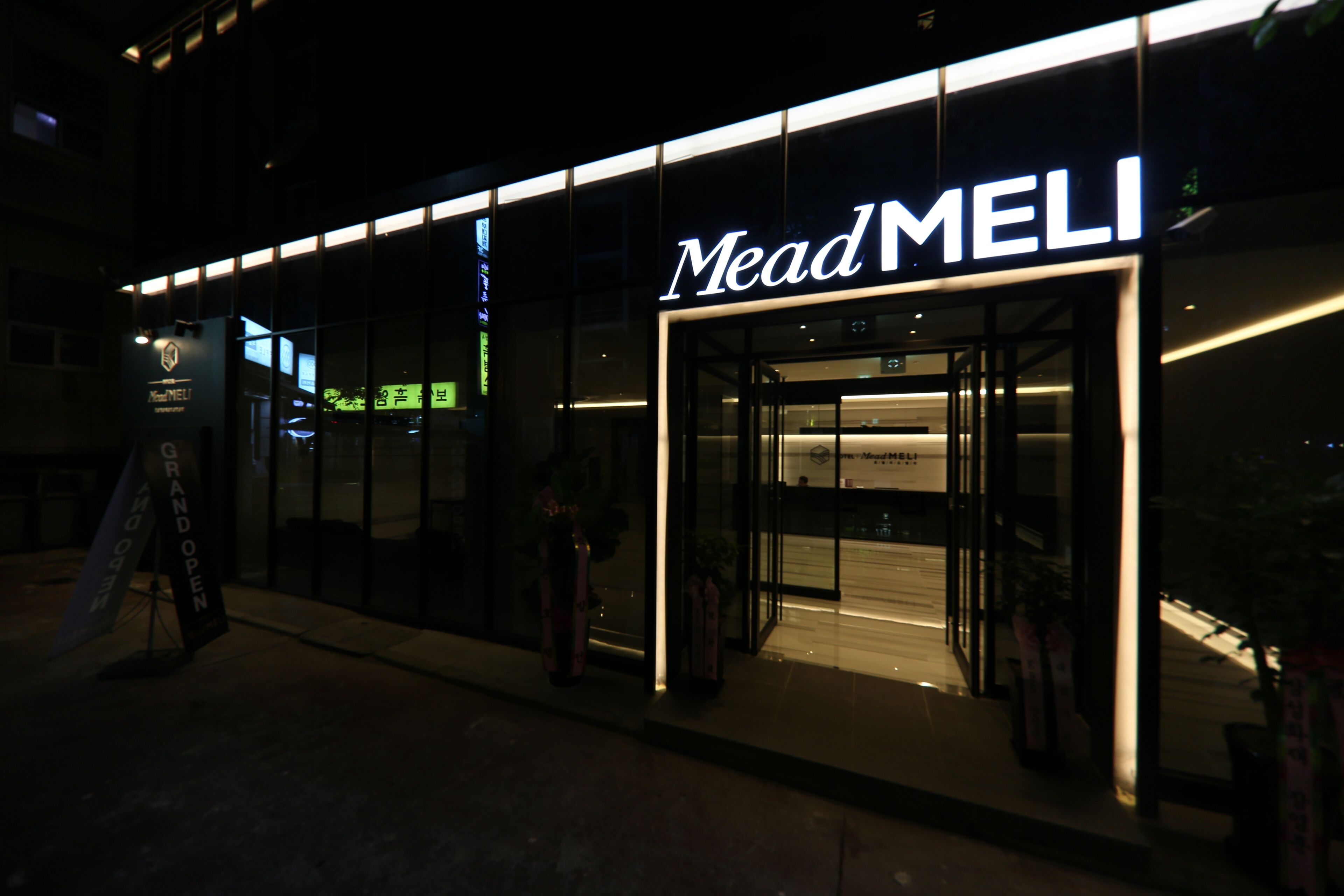 A storefront with the name 'Mead MELI' illuminated in white letters.