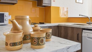 A kitchen with a marble countertop, a microwave, a stove, and a dishwasher.
