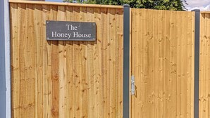Una valla de madera con un letrero que dice "The Honey House".