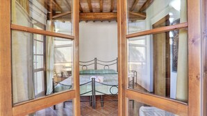 Une chambre à coucher avec un lit, une table de chevet et une fenêtre avec des cadres en bois.