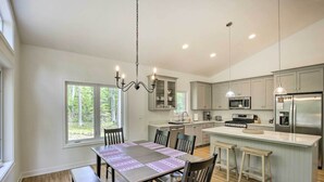 A modern kitchen with a large island, built-in appliances, and ample natural light from large windows. - Door County Family Home: 3 Mi Whitefish Dunes (Sturgeon Bay)