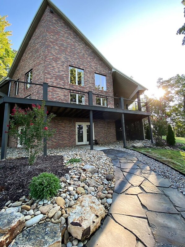 A two-story brick house with a covered porch and a stone pathway leading to the entrance. - A mountain experience seen from above…a view that takes your breath away! (Jamestown)