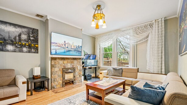 Una sala de estar con chimenea, sofá, mesa de centro y televisor.