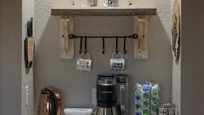 A kitchen counter with coffee-making equipment, a coffee sign, and a rustic wooden shelf. - Holiday Decorations l Spacious l 1 Mile to Downtown Bandera l Dog Friendly (Bandera)