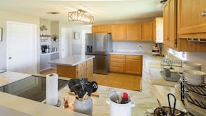 A modern kitchen with wooden cabinets, stainless steel appliances, and marble countertops. - Holiday Decorations l Spacious l 1 Mile to Downtown Bandera l Dog Friendly (Bandera)