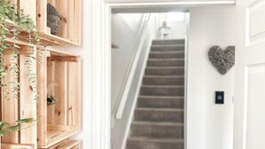 A staircase leading to a second floor, wooden shelving units with plants, and a heart-shaped decoration on the wall. - 2 bedroom accommodation in Colinsburgh, near Elie and Anstruther (Colinsburgh, near Elie and Anstruther)