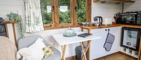 A compact kitchen with a window, a small dining table, and a cozy seating area.