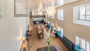 A spacious dining area with high ceilings, wooden floors, and large windows allowing natural light. - 12 bedroom accommodation in Pembroke (Pembroke)