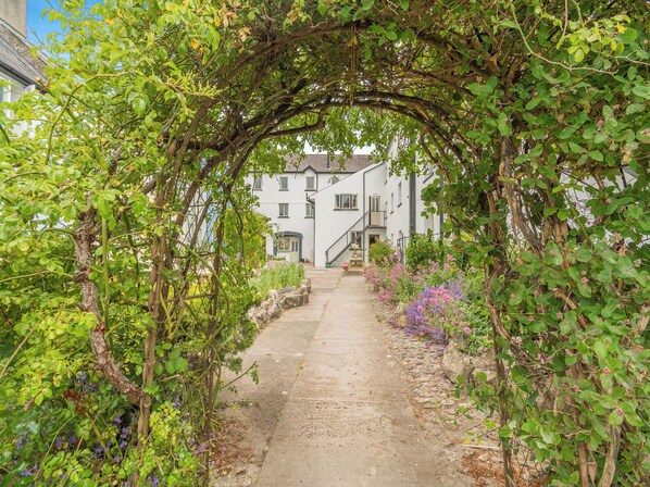 A pathway leading to a white building with a staircase.