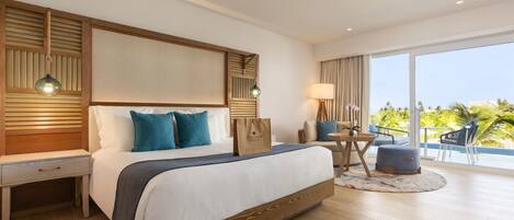 Habitación de hotel con una cama grande, una mesita de noche, un escritorio, una silla y vistas al exterior.