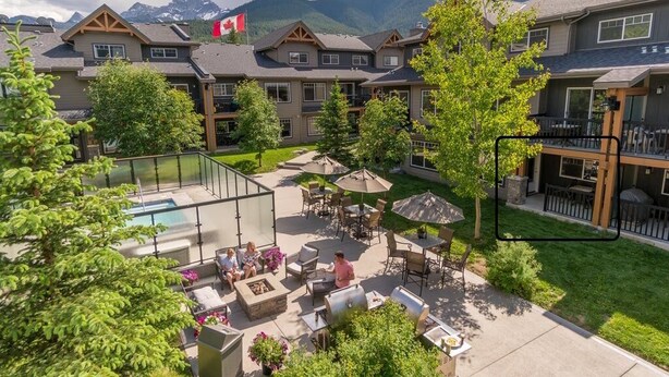 Un complexe hôtelier doté d’une piscine, d’un espace extérieur aménagé et offrant une vue sur les montagnes.