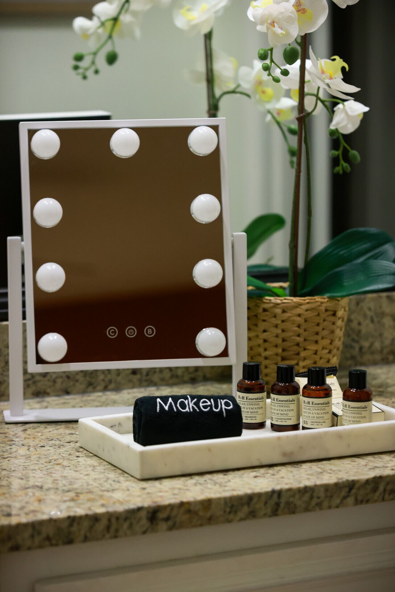 A vanity setup with a mirror, makeup bag, and essential oil bottles.