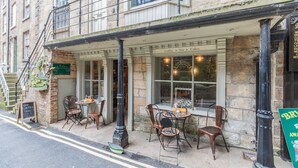 A cafe with outdoor seating, a signboard, and a staircase leading to an upper floor. - The Shepherd's Rest (Whitby)