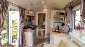 A compact kitchen with a sink, stove, and dining area. - The Shepherd's Rest (Whitby)