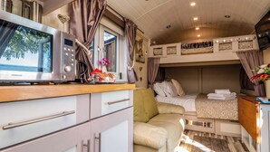 A compact, well-lit interior with a kitchenette, a bed, and a seating area. - The Shepherd's Rest (Whitby)