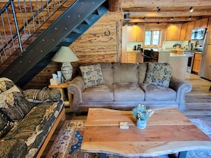 A cozy living room with a sofa, a coffee table, and a patterned rug.