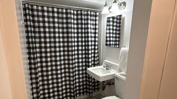 Combined shower/bathtub, towels, shampoo, toilet paper
