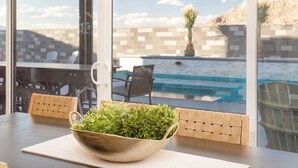 A dining area with a table, chairs, and a bowl of greenery. - The Gambit Luxury Zion Home Pool Hot Tub Sleeps 14 (Hurricane)