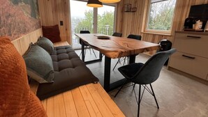 A cozy room with a wooden bench, a dining table with chairs, and a kitchen area with a coffee machine. - Bergquell Willingen App. 2 (Willingen)