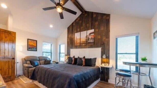 Een slaapkamer met een bed, een bureau en een stoel.