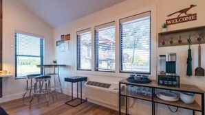 Een moderne keuken met een barkruk, een koffieapparaat en een welkomstbord.