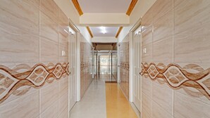 A hallway with marble walls and a yellow carpet. - Itsy Hotels HSR Comfort (Bengaluru)