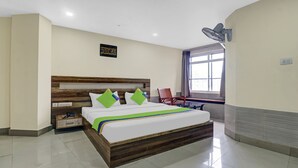 Une chambre d’hôtel avec un lit en bois, un bureau et une chaise.