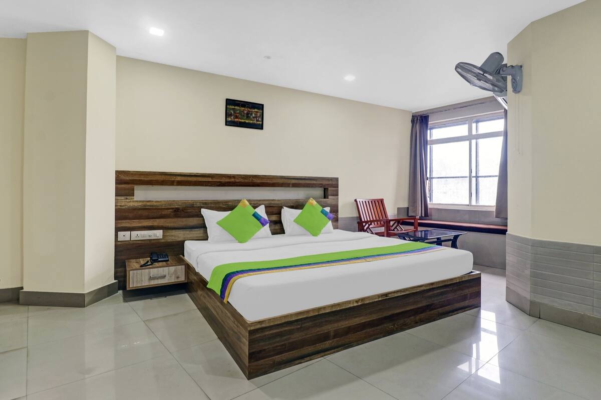 Una habitación de hotel con una cama de madera, un escritorio y una silla.