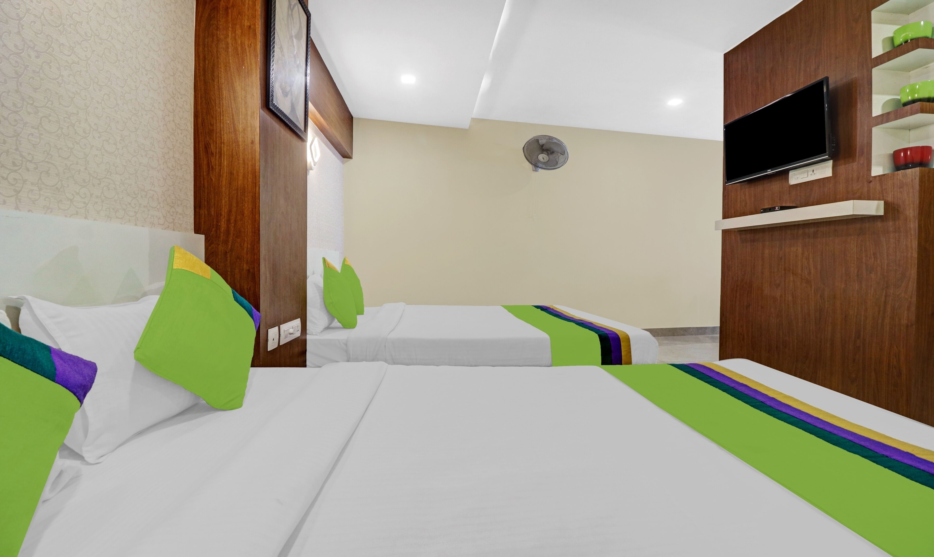 Een hotelkamer met twee bedden, een televisie en een plank met kommen.