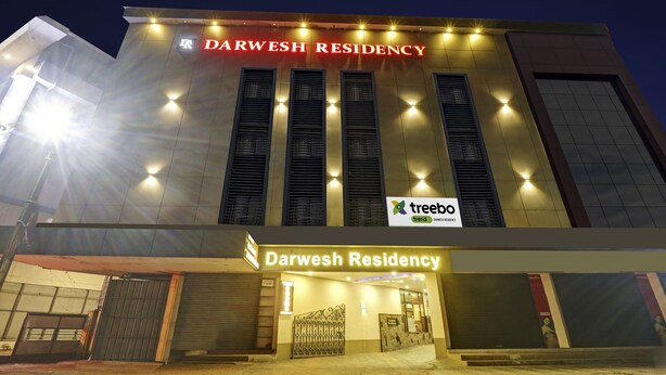 Un bâtiment moderne portant l’enseigne « Darwesh Residency » et arborant le logo de « treebo trend ».