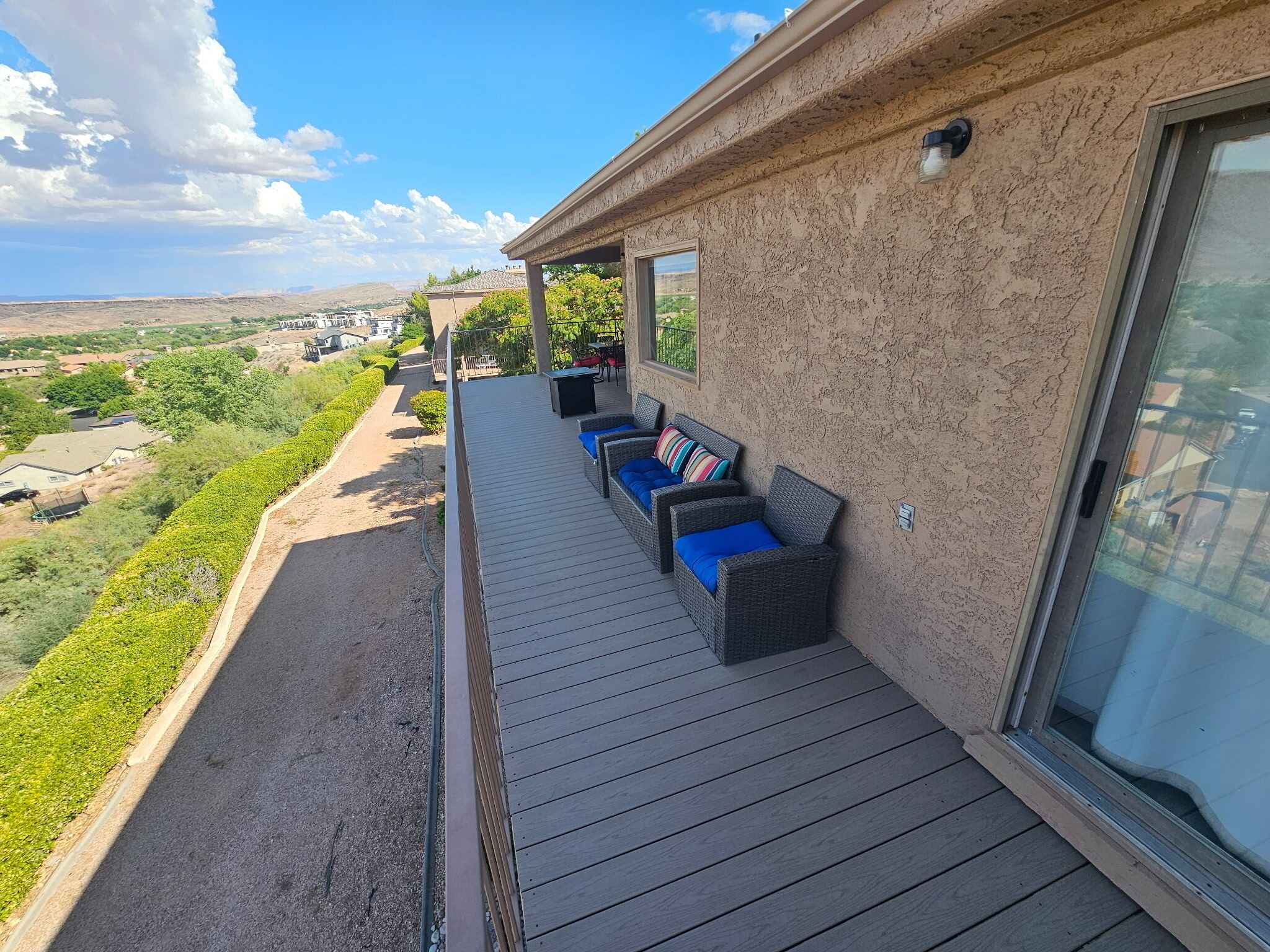 Ein Balkon mit Sitzgelegenheit und Blick auf eine hügelige Landschaft.
