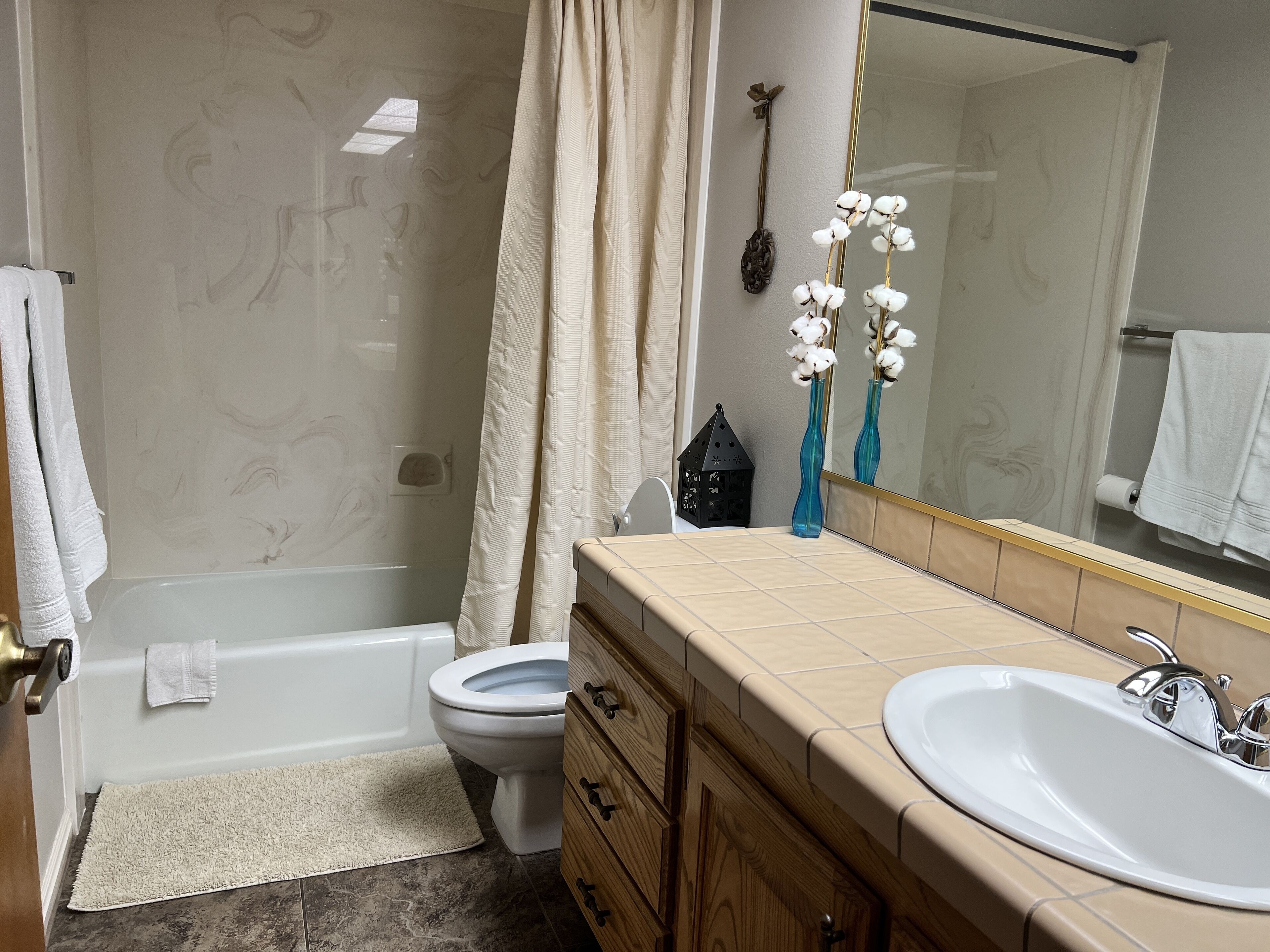 Un bagno con vasca, WC, mobile lavabo e specchio.