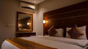 A hotel room with a large bed, a mirror, an air conditioning unit, and a nightstand. - Ahlin 2 Serviced Apartment (Riyadh)