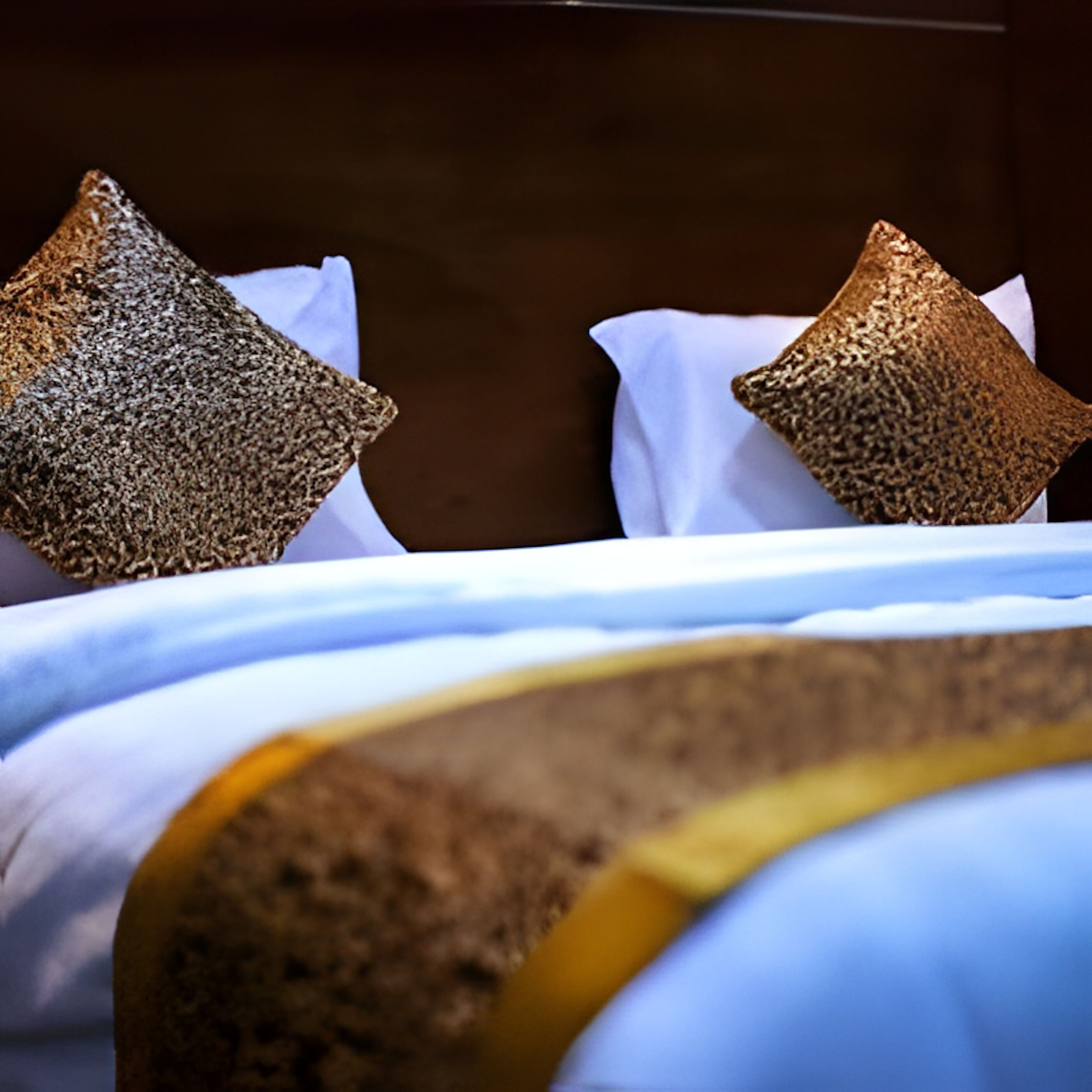 A bed with a white sheet and two textured pillows.