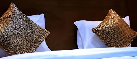 A bed with a white sheet and two textured pillows.